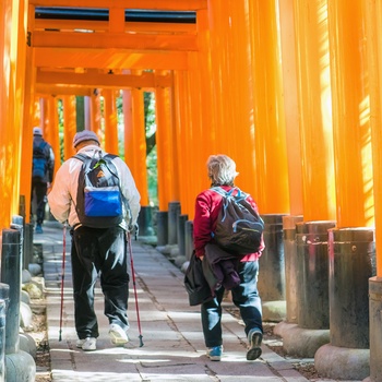 Ældre par på vej gennem torri portene i Fushimi Inari-helligdommen, Kyoto i Japan 