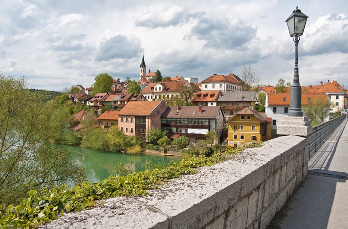 Bro over floden Krka med Novo mesto i baggrunden, Slovenien