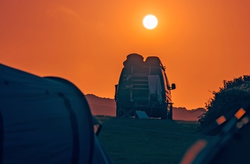 Autocamper i solnedgang på campingplads i Cornwall, England