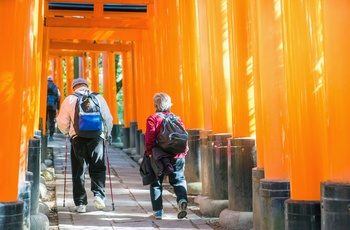 Ældre par på vej gennem torri portene i Fushimi Inari-helligdommen, Kyoto i Japan 