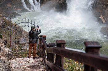 Mand tager billede af Savica-vandfaldet i Triglav National Park om efteråret, Slovenien