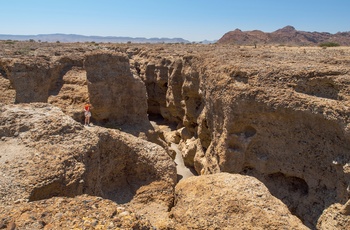 Ung kvinde spejder ud over kløften Sesriem Canyon i Namibia