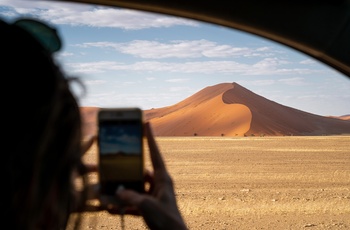 Turist tager billeder med mobilen i Sossusvlei, Namib-Naukluft National Park, Namibia